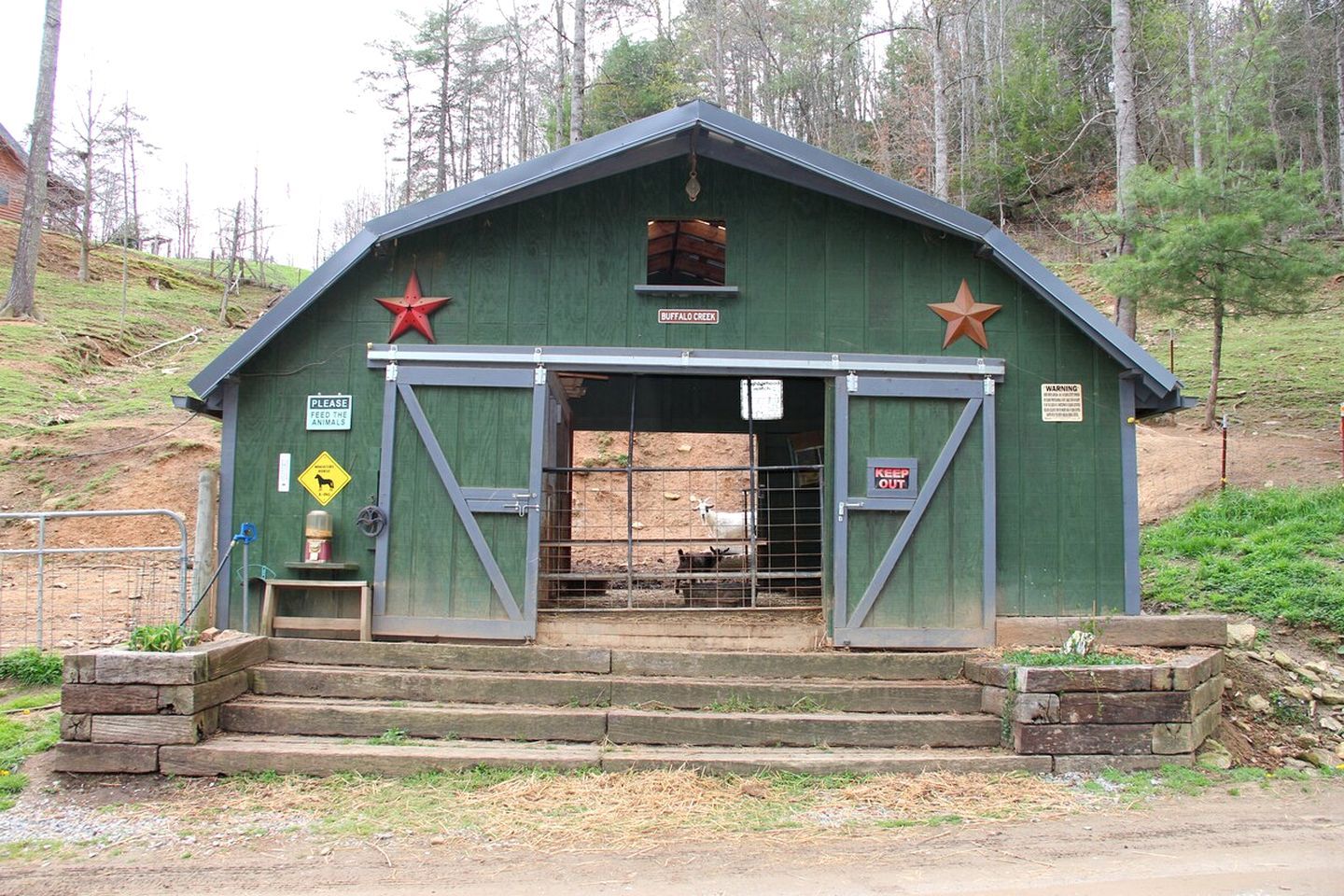 A green building with a star emblem, a warning sign, and a 'Keep Out' sign.