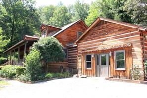 Une cabane en rondins dotée d’une véranda et d’un porche abrité.