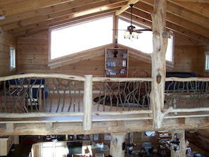 A rustic wooden cabin with a loft bedroom, a dining area, and a kitchen. - Luxury Vacation Rental with a Hot Tub for Rent in Clyde, North Carolina (Clyde)