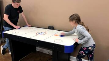 Zwei Personen spielen Tischhockey auf einem Tisch mit einem Puck und einem Puckhalter.