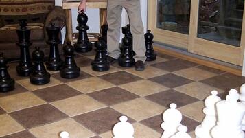 A man leaning over a chessboard with pieces arranged in two rows.