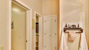 A hallway with a white door, a sign indicating a toilet and a 10 cents fee, and a towel rack with a towel.