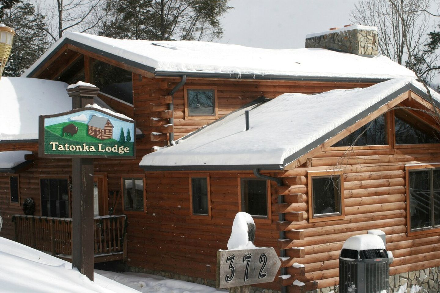 A wooden lodge with a sign reading 'Tatonka Lodge' and a number '372' displayed.