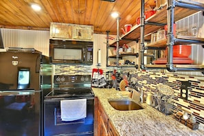 A kitchen with a refrigerator, stove, microwave, and a sink. - Glamping Caboose Rental Perfect for Families near Clyde, North Carolina (Clyde)