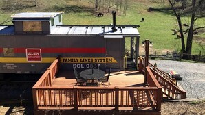 A stationary train car with a wooden deck and seating area, labeled 'Family Lines System' and 'SCL 0887'.