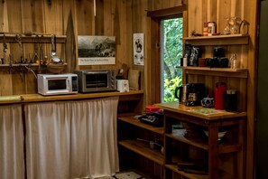 Une cuisine avec des murs en bois, une fenêtre et divers appareils de cuisine.