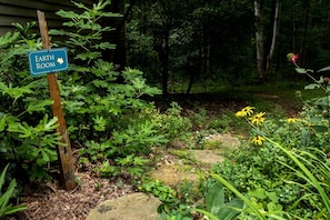 A garden with a sign indicating an Earth Room, surrounded by various plants and a stone pathway. - Cozy Ground Floor Suite in a Beautiful Farmhouse for a Unique Getaway in Afton, Virginia (Afton)