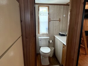 Un baño pequeño con inodoro, lavamanos y ventana.