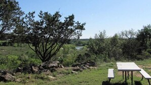 Un espace pique-nique équipé d’une table et de bancs, entouré de rochers et d’arbres.