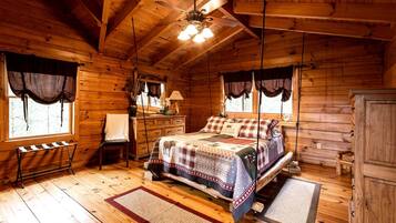 Un dormitorio de cabaña de madera con una cama, un escritorio, una silla y un armario.