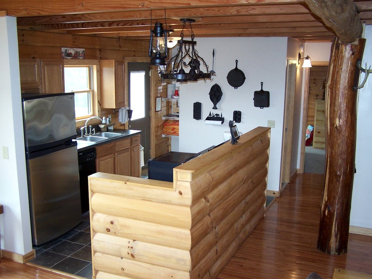 Une cuisine avec un banc en bois, un réfrigérateur et une cuisinière.