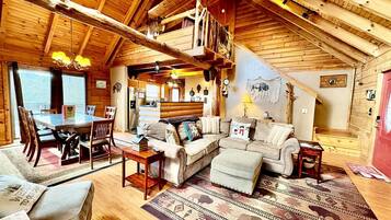 L’intérieur d’un chalet confortable, avec une salle à manger, un coin salon et une cheminée.