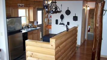 A kitchen with a wooden bench, a refrigerator, and a stove.