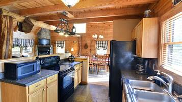 A kitchen with wooden cabinets, a stove, a microwave, and a refrigerator.
