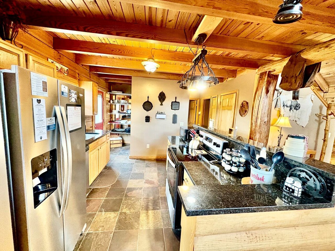 A kitchen with a refrigerator, stove, and granite countertop.
