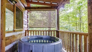 A hot tub on a wooden deck with a wooden railing, surrounded by trees. - Beautiful Waterfront Cabin with Hot Tub near Winston-Salem, North Carolina (Elkin)