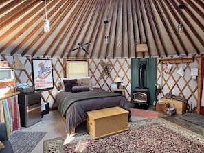 Une pièce confortable avec un lit, un petit bureau, un radiateur et un mur en bois.