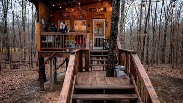Eine Holzhütte mit Terrasse, Bar und Schild für einen Biergarten.