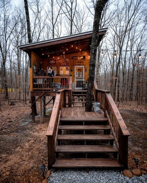 A wooden cabin with a deck, a bar area, and a sign indicating a beer garden.
