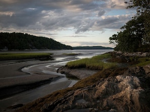 A coastal landscape with a river, rocky shore, and forested hills. - Off-The-Grid Cottage Rental with Beautiful Views on Crow Island, Maine (Arrowsic)