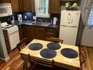 Une cuisine avec des meubles de rangement en bois, une cuisinière blanche, un évier et un réfrigérateur.
