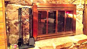 A stone wall with a metal fireplace and a window. - Charmingly Rustic Weekend Getaway in the Mountains near Pittsburgh, Pennsylvania (Champion)