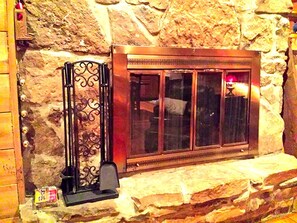 A stone wall with a metal fireplace and a window. - Charmingly Rustic Weekend Getaway in the Mountains near Pittsburgh, Pennsylvania (Champion)