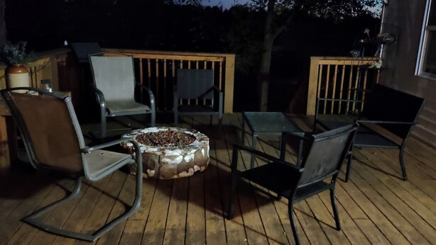 A wooden deck with outdoor furniture, including chairs and a table, and a fire pit. - Charming Farmhouse Glamping Cabin in Sparta, Tennessee (Sparta)