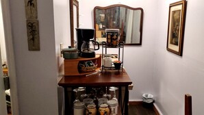 A hallway with a wooden table displaying kitchen items, a mirror, and framed artwork on the walls. - Charming Farmhouse Glamping Cabin in Sparta, Tennessee (Sparta)