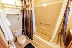 A bathroom with a toilet, a bathtub, and a shower curtain. - Delightful Weekend Getaway for the Perfect Outdoor Experience near Mansfield, Ohio (Fredericktown)