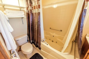 Un baño con inodoro, bañera y cortina de ducha.