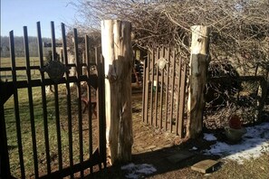 A wooden gate leading to a property with a brick pathway and a snow-covered ground. - Idyllic Tiny House Rental on a Peaceful Farm in Middle Tennessee (Sparta)