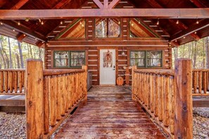 A wooden lodge with a central door, wooden railings, and a covered walkway.