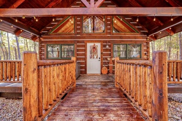 A wooden lodge with a central door, wooden railings, and a covered walkway.