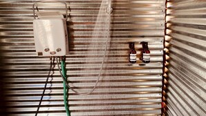 A shower with a control box and two bottles of shampoo. - Glamorous California Campsite Retreat with Great Views (New Cuyama)