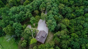 Luchtbeeld van een huis omringd door dicht bos.