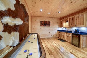 Una habitació amb taula de bitlles, armaris de fusta i una paret recoberta de pell.