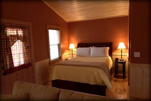 A bedroom with a bed, two bedside lamps, a window with curtains, and a wooden ceiling. - Luxury Cabin Rental with Beautiful Water Views near Charlotte, North Carolina (Elkin)