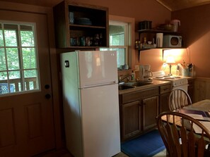 A compact kitchen with a refrigerator, microwave, stove, and wooden cabinets. - Luxury Cabin Rental with Beautiful Water Views near Charlotte, North Carolina (Elkin)