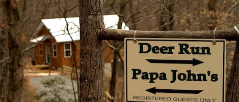 Señal que indica las direcciones hacia 'Deer Run' y 'Papa John's', con la indicación: 'Solo para huéspedes registrados'.