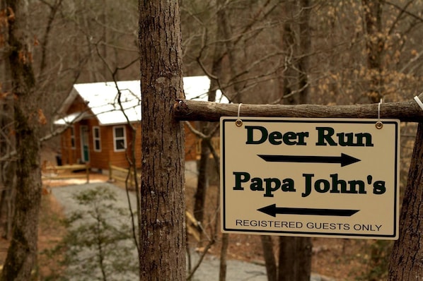 A sign indicating directions to 'Deer Run' and 'Papa John's' with a note for 'Registered Guests Only.' - Luxury Cabin Rental with Beautiful Water Views near Charlotte, North Carolina (Elkin)