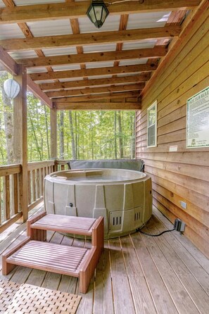 A wooden deck with a hot tub, wooden steps, and a wooden railing. - Rustic Cabin on 28-Acre Property in the Foothills of the Blue Ridge Mountains (Elkin)