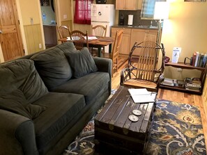 Un salon avec un canapé, une table basse en bois et un tapis à motifs.
