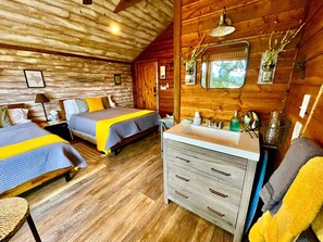 A cabin-style room with two beds, a wooden ceiling, a sink, and a mirror. - Tranquil Dripping Springs Vacation Rental Ideal for Texas Getaways (Dripping Springs)