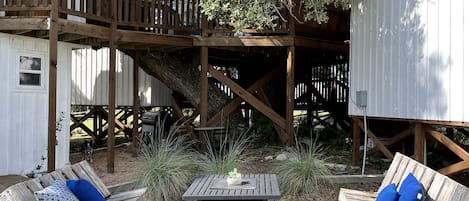 Una terraza de madera con asientos exteriores y una pequeña mesa.