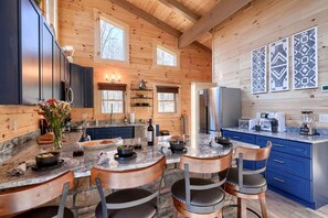Una cocina amplia con paredes de madera, encimeras de granito y electrodomésticos modernos.