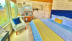 Quarto com cama, cadeira, escrivaninha e janela.