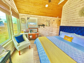 Une chambre à coucher avec un lit, une chaise, un bureau et une fenêtre.