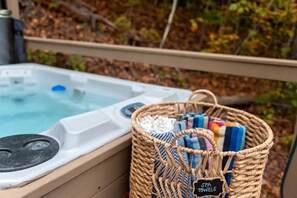 Een jacuzzi met bedieningspaneel, een mand met handdoeken en een bordje met de tekst 'SPA HANDDOeken'.