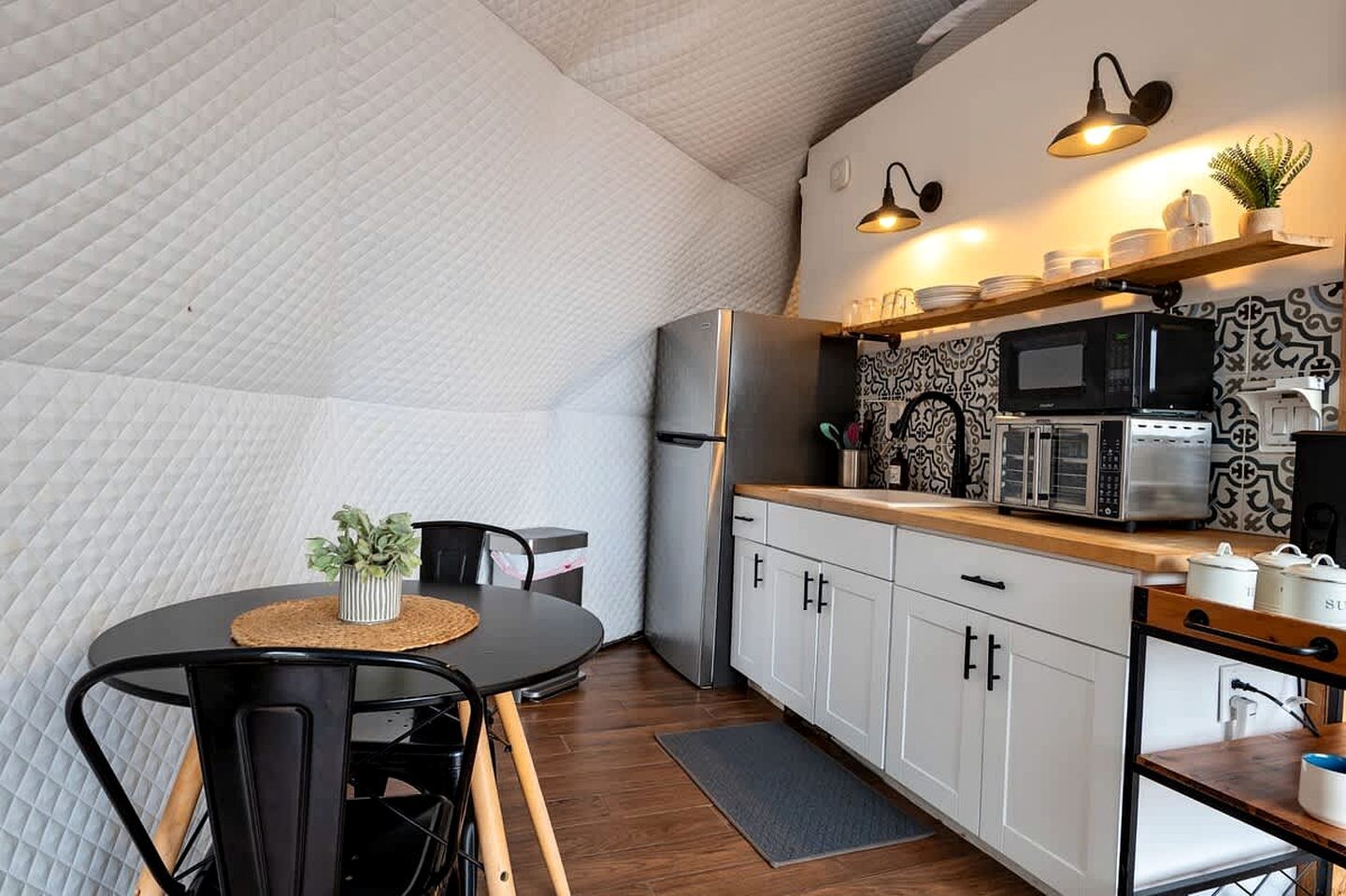 A compact kitchen with a dining area, a microwave, and a refrigerator.